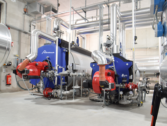 Großbrenner & Warmwasserkessel: Industrieanlagen von bösch in einem hohen grauen Raum | © Walter Bösch GmbH & CO KG