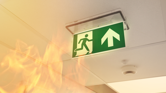 Notausgangschild mit Flammen und Feuermelder