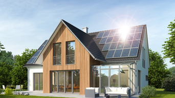 Modernes Einfamilienhaus mit Solarpanels auf dem Dach, großer Terrasse und grünem Garten | © KB3 - stock.adobe.com
