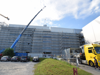 Blauer Kran hebt Kube auf das Dach. | © bösch - heizung, klima, lüftung