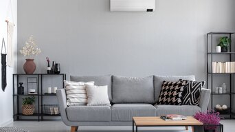 Wohnzimmer mit einem grauen Farbstil und Couch mit Split-Klimaanlage