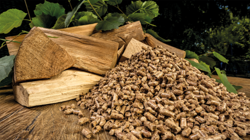 Gestapeltes Stückholz und Holzpellets auf einem Holztisch – Vergleich und Entscheidungshilfe für eine moderne Pelletheizung