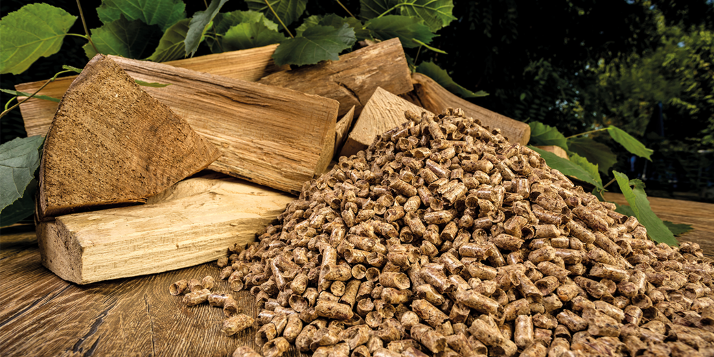 Gestapeltes Stückholz und Holzpellets auf einem Holztisch – Vergleich und Entscheidungshilfe für eine moderne Pelletheizung