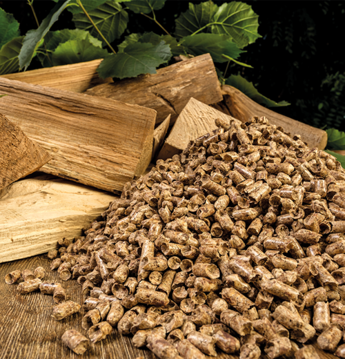 Gestapeltes Stückholz und Holzpellets auf einem Holztisch – Vergleich und Entscheidungshilfe für eine moderne Pelletheizung