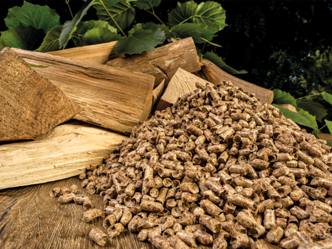 Gestapeltes Stückholz und Holzpellets auf einem Holztisch – Vergleich und Entscheidungshilfe für eine moderne Pelletheizung