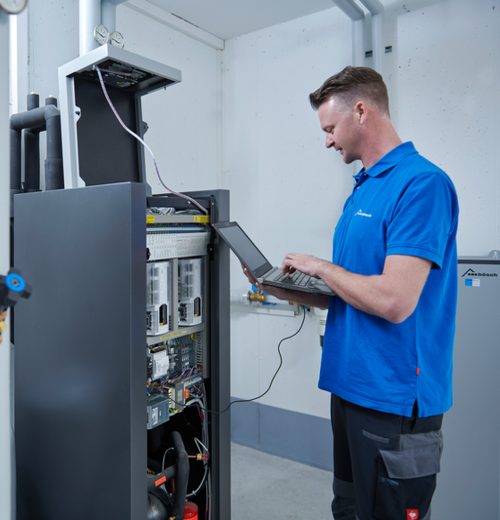 Techniker vom bösch Kundendienst überprüft System eines Kunden mit einem Laptop