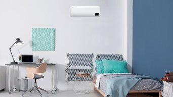 RAC Wandgerät in einem Schlafzimmer oben zwischen einem Bett und einem Schreibtisch mit Lampe. | © Samsung/SamCool